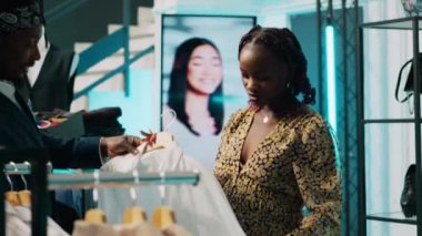 Hamilelik kıyafetleri arayan Afrikalı Amerikalı alışverişçi. Alışveriş merkezinde alışveriş yapıyor. Hamile müşteriler için öneriler sunan çalışanlar, modaya uygun tasarımcılar. Kamera A.
