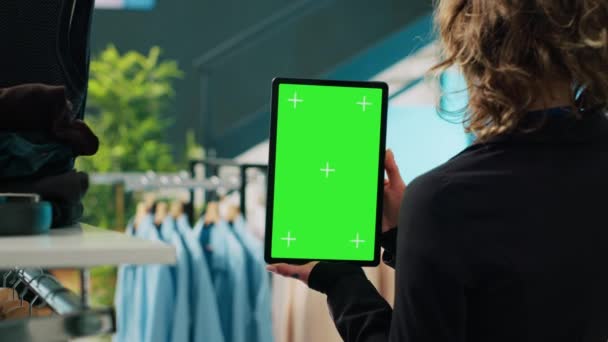 아이템을 판매하는 템플릿을 사용하여 백화점에 표시된 스크린 디스플레이가있는 태블릿을 보유하는 — 비디오