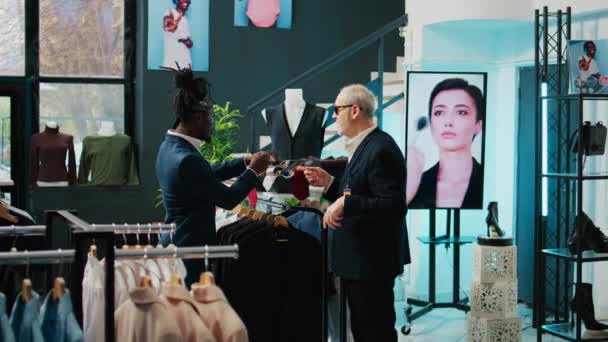 著名的服装设计师命令店员帮他的非洲裔美国客户找领带 经验丰富的资深裁缝进来了 时装设计师购买豪华饰品 摄像头B — 图库视频影像