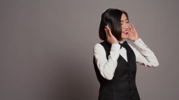 Otel Personeli Müzik Dinlemek Için Kulaklık Kullanıyor Gri Arka Planda — Stok video