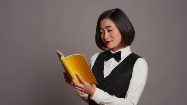 Recepcionista Asiática Lendo Livro Literatura Sobre Fundo Cinza Desfrutando Hobby — Vídeo de Stock