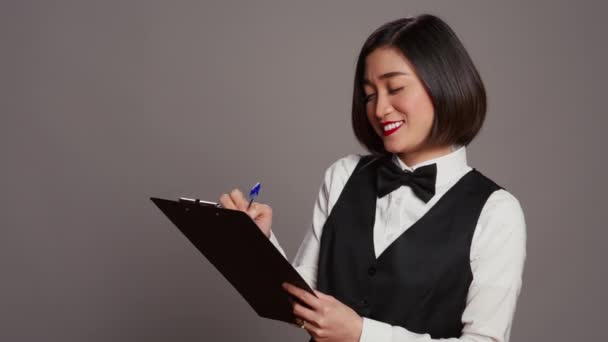 Asiatischer Hotel Concierge Erstellt Eine Checkliste Der Registrierungen Und Arbeitet — Stockvideo