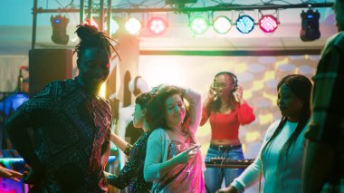 Erkek dansçı kulüpte eğleniyor, dans pistinde dans ediyor insanlarla dolu. Gece kulübünde dans eden ve elektronik müzikle parti yapan çok ırklı bir arkadaş grubu. Üçayak atışı.