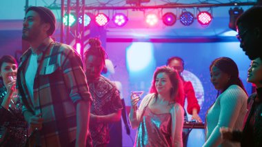 Gece kulübünde dans eden rahat bir insan, canlı müzik hayatına devam ediyor ve insanlarla eğleniyor. Neşeli bir grup arkadaş DJ 'le dans pistinde parti yapıyor. Üçayak atışı.