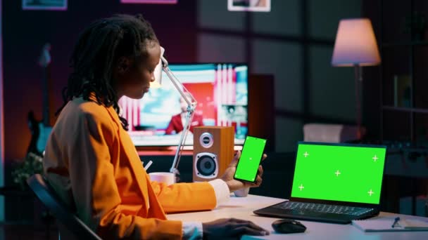 非洲裔美国女孩使用智能手机和带有绿色屏幕的Pc 看着现代设备运行着相同的孤立的模拟模板 年轻女人检查彩色屏幕 相机A — 图库视频影像
