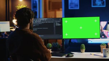 Dairenin kişisel ofisinden bilgisayar destekçisi olarak çalışan serbest çalışan bir adam yeşil ekranda kodlama yapıyor. Yazılım geliştiricisi evdeki bilgisayar, kamera A 'ya kod satırları yazıyor.