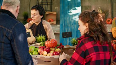Çeşitli çiftçiler yerel gıda pazarındaki müşterilere çeşitli meyve ve sebzeler gösteriyor. Erkek ve kadın eko ev yapımı organik ürünler satıyor, biyo-taze ürünleri var..