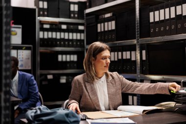Dedektif polis raporlarını analiz ediyor, gizli suç dosyalarını kontrol ediyor. Resmi takım elbiseli özel dedektif gizemli kurban dosyaları keşfediyor, arhiv odasında fazla mesai yapıyor.