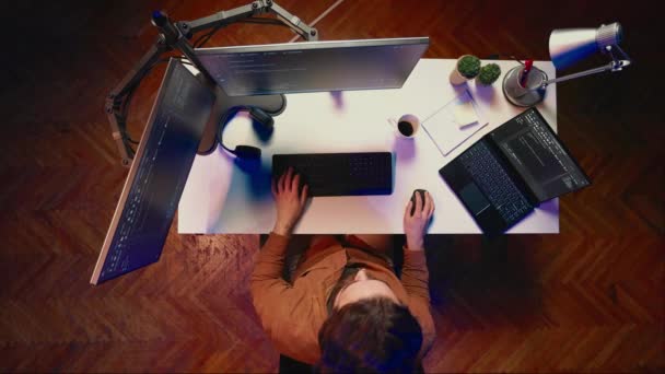 アパートの個人的なオフィスからItサポートジョブをしている自己雇用男性のトップダウンビュー Pcでコーディング コーヒーを飲む 自宅でコンピュータ上のコードの行を書くソフトウェア開発者 空中撮影 — ストック動画