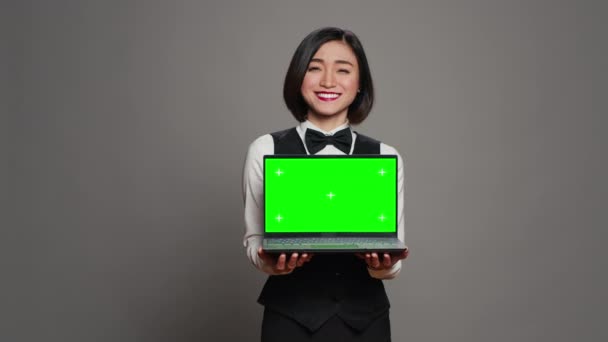 Azjatycki Konsjerż Hotelowy Trzymający Komputer Zielonym Ekranem Przed Kamerą Prezentujący — Wideo stockowe