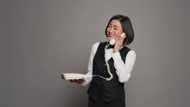 Asyalı Resepsiyonist Stüdyodaki Sabit Telefon Görüşmesine Cevap Veriyor Eski Tip — Stok video
