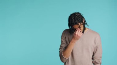 Acı çeken, baş ağrısı çeken, sağlık sorunları olan Ortadoğulu yaralı bir adam. Yaralı BIPOC çalışanı baş şakaklarını ovuyor, rahatsız edici gerginlik, stüdyo geçmişi, kamera A