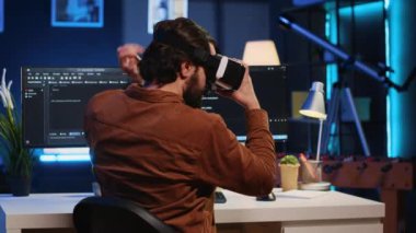 Uzaktan kumandalı yazılım geliştirici evdeki kişisel ofiste VR gözlük kullanarak Javascript programlama yapıyor. Sanal gerçeklik kulaklığı takan bilişim mühendisi kod satırlarını, kamera A 'yı görselleştirmek için
