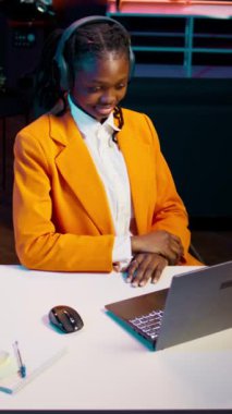Dikey Afrikalı Amerikalı kız profesörü dinliyor, son dersi tartışıyor, açıklamaları anladıktan sonra not alıyor. Akademik platformdaki çevrimiçi okul derslerine katılan öğrenci