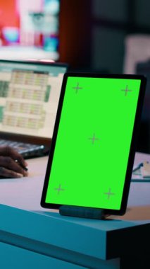 Dikey Video Afrikalı Amerikalı işletme öğrencisi izole edilmiş yeşil ekrana bakıyor, vergi hizmetleri hakkında bilgi edinmek için akademik yazılım tablosunu inceliyor. Boş telif alanı düzenine sahip tablet kullanan kız