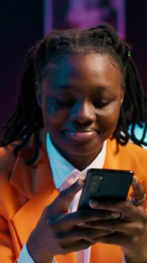 Dikey Video Koleji öğrencisi ödevini laptopta yapıyor ve telefonda mesajlaşıyor, sosyal medya uygulamalarını kontrol etmek için okul tatilinin tadını çıkarıyor. Görev arayan ve akıllı telefon kullanan bir kız. Kamera A.