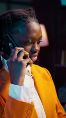 Dikey Video Öğrencisi, ders programları ve online derslere dayalı zaman çizelgeleri düzenlemek için profesörünü arıyor. Afrika kökenli Amerikalı kız akıllı telefondan konuşuyor.