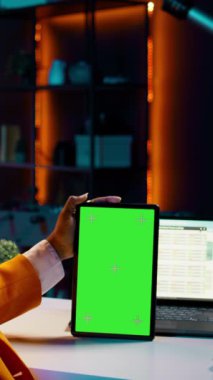Vertical Video Üniversitesi öğrencisi tablet üzerinde yeşil ekrana bakıyor nakit planı yazılımını kullanmayı öğreniyor, online sınıflarla işletme ve finans okuyor. Kopyalama alanına bakar, veri analizi yapar