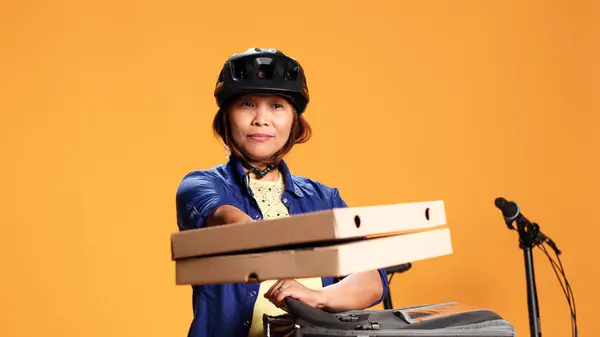 Turuncu Stüdyo Arka Planında Izole Edilmiş Kurye Kadın Müşteriye Pizza — Stok fotoğraf