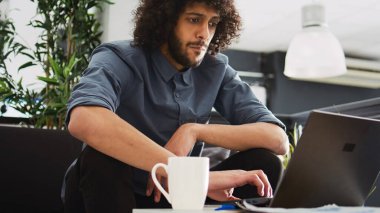 Dizüstü bilgisayar ve kağıtları kullanarak proje araştırmaları için veri dosyalarını karşılaştıran bir başlangıç uzmanı. Başarılı satış istatistikleriyle gelişim planını yürüten genç bir çalışan..