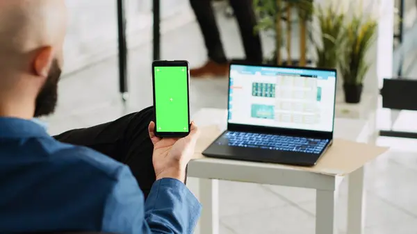 Çalışan Bilgisayarın Istatistik Tablosuna Bakarken Yeşil Ekranlı Telefonu Tutuyor Şirkette — Stok fotoğraf
