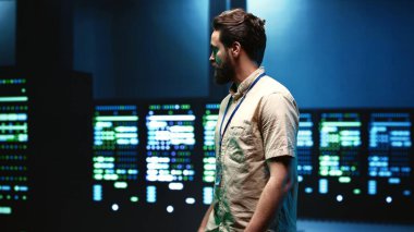 Gelişmiş veri depolama altyapısını barındıran sunucu odasında yürüyen mühendis, yüksek yoğunluktaki bilişim ekipmanlarını çalıştırmak için gerekli kritik iş yüklerini destekliyor