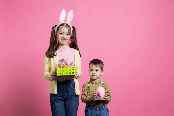 Małe Słodkie Dzieci Pokazujące Wielkanocne Ozdoby Zabawki Studio Pozujące Świątecznej — Zdjęcie stockowe