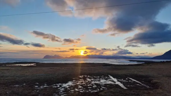 雪山と凍った農地の隣の黄金の時間の海岸線 ワインの天気とアイスランドの風景 丘と日没のオープンウォーターで素晴らしい田園風景 — ストック写真