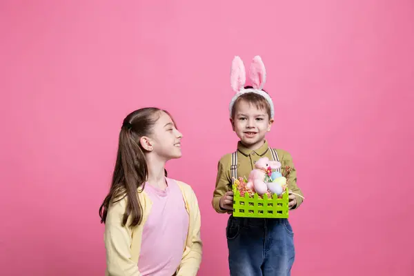 Şirin Erkek Kız Kardeşler Sepetin Içinde Boyanmış Yumurta Tavşan Oyuncakları — Stok fotoğraf