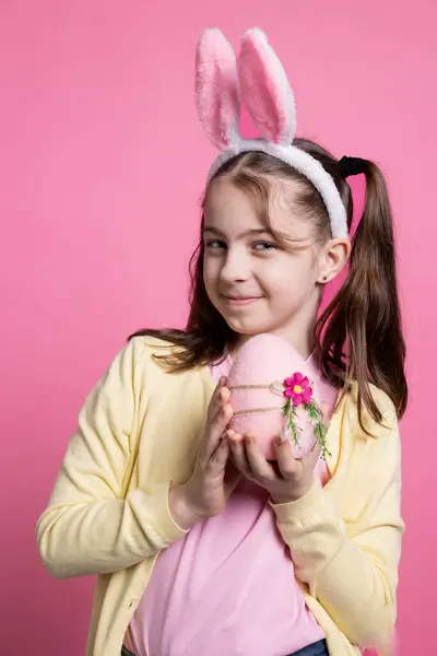 Παιχνιδιάρα Μαθήτρια Αυτιά Κουνελιού Κρατώντας Ένα Ροζ Αυγό Στην Κάμερα — Φωτογραφία Αρχείου