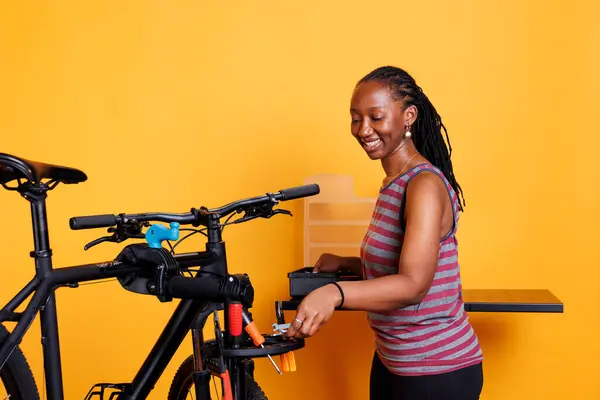 Фотография Молодой Чернокожей Женщины Готовящей Профессиональное Оборудование Обслуживания Велосипедов Энергичная — стоковое фото