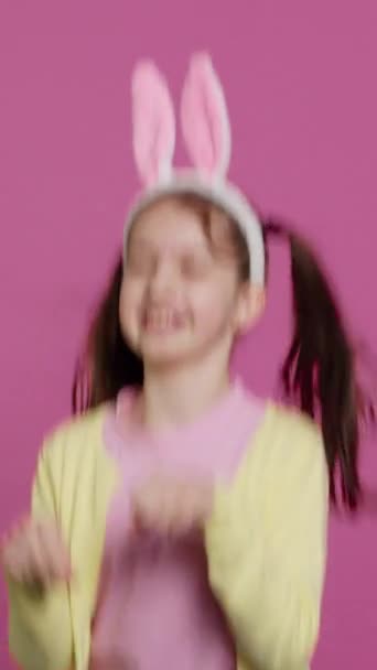 Vertical Video Freudiges Unbeschwertes Schulmädchen Das Studio Herumspringt Ein Kaninchen — Stockvideo