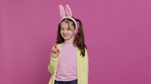 사랑스러운 달콤한 소녀는 손가락을 스튜디오에서 포즈와 부활절 선물을받을 행운과 재산을 — 비디오