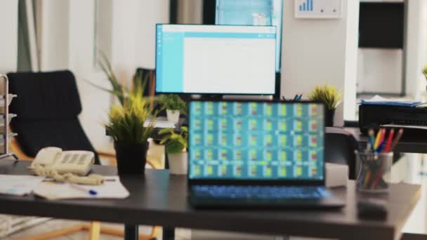 写字台在空荡荡的办公室里 笔记本电脑显示收集到的证券交易数据 以制定交易策略 公司工作场所显示交易平台的笔记本电脑屏幕上的外汇分析 — 图库视频影像