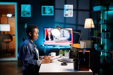 Afrika kökenli Amerikalı üniversite öğrencisi, kadın bir meslektaşla dizüstü bilgisayarla konuşurken evrak işlerini hallediyor. Çevrimiçi tartışan iki genç kadın, taşınabilir bilgisayarda video görüşmesi..