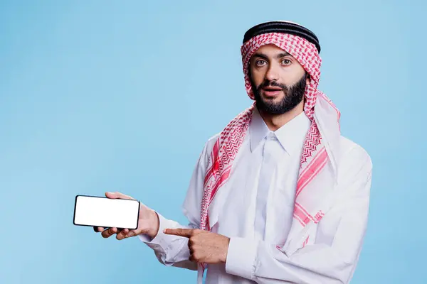 Muslim Man Holding Smartphone White Screen Horizontal Mode Pointing Finger — Stock Photo, Image