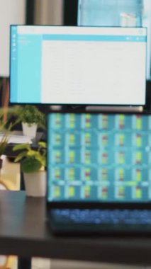 Boş bir ofiste dikey video masası. Borsa stratejileri geliştirmek için toplanan borsa verilerini dizüstü bilgisayarla gösteriyor. Şirket iş yerindeki dizüstü bilgisayar ekranındaki eski analizler ticaret platformunu gösteriyor