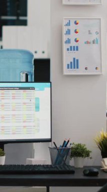 Dikey video boş muhasebe bürosu denetleme, tahmin ve finansal analiz amacıyla kullanılır. Şirket çalışma alanı içinde kimse yok ve bilgisayar ekranlarındaki iş rakamları açık