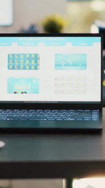 Dikey video borsa diyagramları, boş işyerlerinde dizüstü bilgisayarda duran tablolar ve hisse senedi rakamları. Finans departmanındaki dizin ekranında gösterilen işlem listeleri