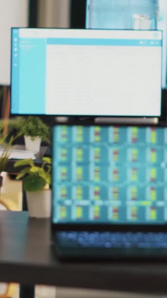 Вертикальне Відео Деск Порожньому Офісі Ноутбуком Показує Дані Фондового Біржа — стокове відео