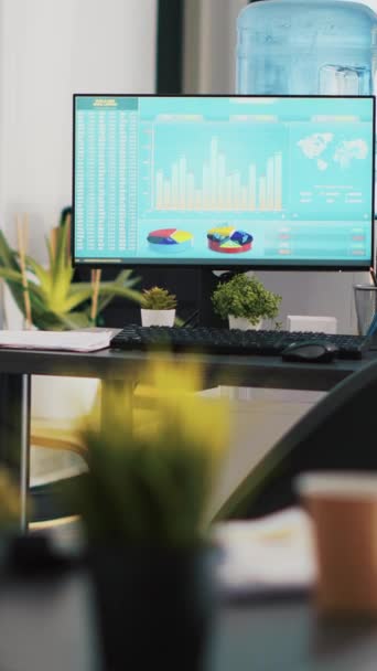 ビジネスオフィスの垂直ビデオコンピュータ画面は リアルタイムで変化する証券取引所の価値を示しています 価格とパイグラフを示す取引インデックスと職場でのデスクトップPcモニター — ストック動画