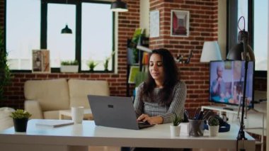 Klavyeye veri yazan, notlar alan, ev ödevlerine yetişen uzaktan kumandalı bir öğrencinin portresi. Neşeli akademisyen evde kalıp ahşap masa temizliği ve kamera A 'da çeşitli işler yapıyor.