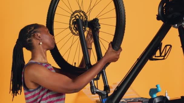 在工作室的后台维修车间 专人将自行车上的车轮从修理台上分离出来 Bipoc Technicians Disassembly Bike Tire Fixing Components Professional — 图库视频影像