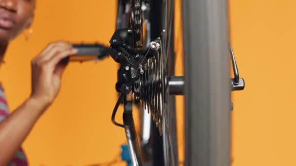 在工作室背景工作室的工作室里做服务的妇女正在测试自行车车轮的特写 修理自行车轮胎 检查断裂转子和链条故障的技术员 — 图库视频影像