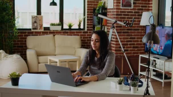 Remote Employee Desk Doing Multitasking Crosschecking Data Laptop Notepad Indian — Stock Video
