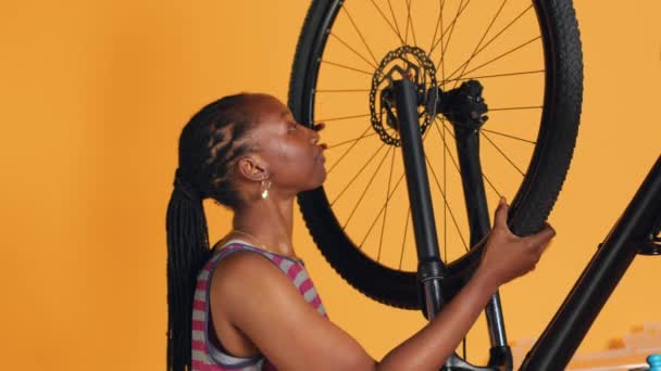 Γυναίκα Κάνει Σέρβις Ποδηλάτου Στο Ατελιέ Στούντιο Φόντο Κατάστημα Ψάχνει — Αρχείο Βίντεο