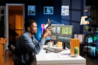 Montaj klipleri üzerinde çalışan video düzenleyici, iş yerindeki renk derecelendirme yazılımını kullanarak. Işıkları ve beyaz dengesi olan bir tasarımcı olarak çalışan genç bir videocu..