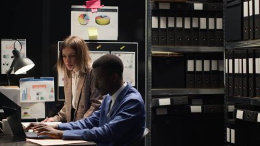 Evraklar ve kanıtlarla tıka basa dolu odada suçları çözmek için geniş çaplı bir soruşturma yürüten kararlı özel dedektifler. Hem kadın hem de erkek müfettişler ipuçlarını dikkatle inceliyor..