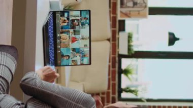 Konforlu dairede uzaktan kumandalı dikey çalışan telekonferans toplantısı sırasında iş arkadaşlarıyla konuşuyor. İş arkadaşlarıyla birlikte internet video görüşmesine katılan bir tele-işçi. Kamerayı yaklaştır.