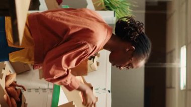 Dikey Video Vegan kişi taze sebze arıyor, yerel sıfır atık eco mağazasından doğal sebze alışverişi yapıyor. Afrikalı Amerikalı müşteri organik gıda ürünlerine bakıyor.